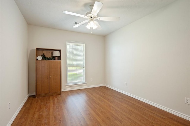 spare room with ceiling fan, baseboards, and wood finished floors