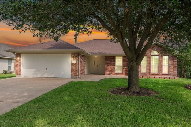 view of front of house featuring driveway, brick siding, a garage, roof with shingles, and a front lawn