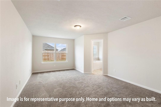 carpeted empty room with a textured ceiling