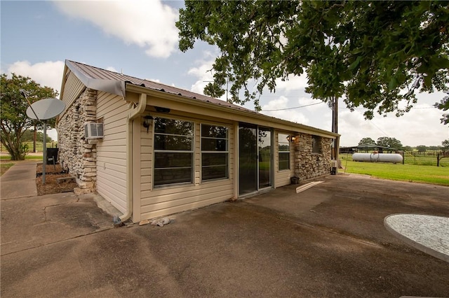 4454 Fm 60 E, Somerville, TX 77879 - view of side of home with a patio area, a metal roof, stone siding, and a yard