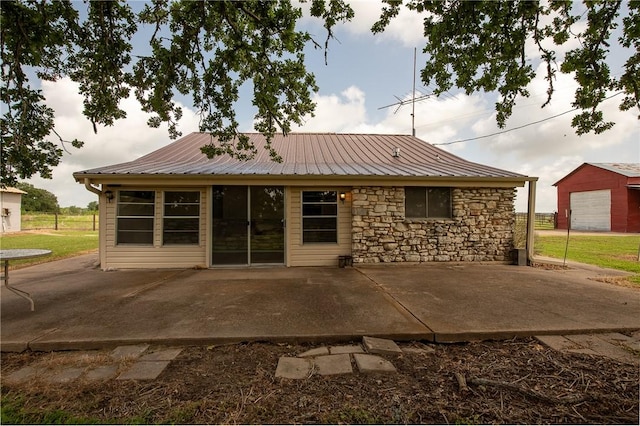 4454 Fm 60 E, Somerville, TX 77879 - rear view of house with a patio, a metal roof, and stone siding