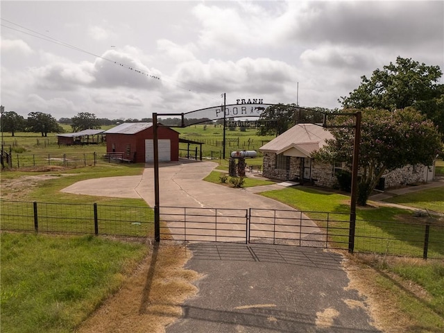 4454 Fm 60 E, Somerville, TX 77879 - view of front facade with a gate, driveway, stone siding, an outdoor structure, and a detached garage