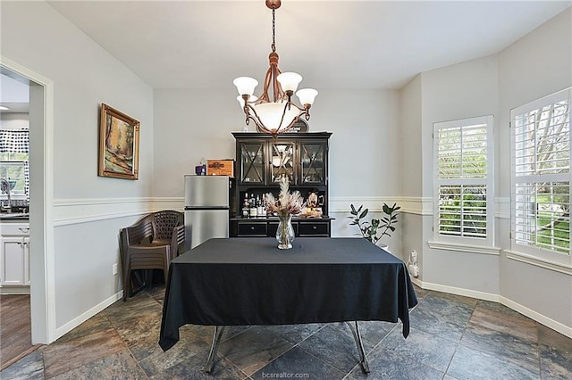 dining area featuring plenty of natural light and a notable chandelier