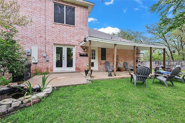 rear view of property with a yard, a patio, and french doors