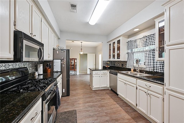 kitchen featuring pendant lighting, decorative backsplash, white cabinetry, and stainless steel appliances