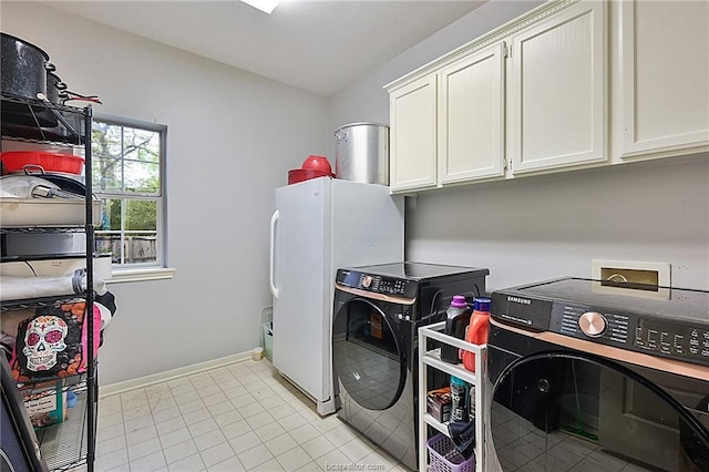 laundry room featuring cabinets, light tile patterned floors, and washer and clothes dryer