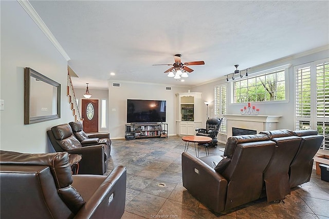 living room with a wealth of natural light, ceiling fan, and ornamental molding