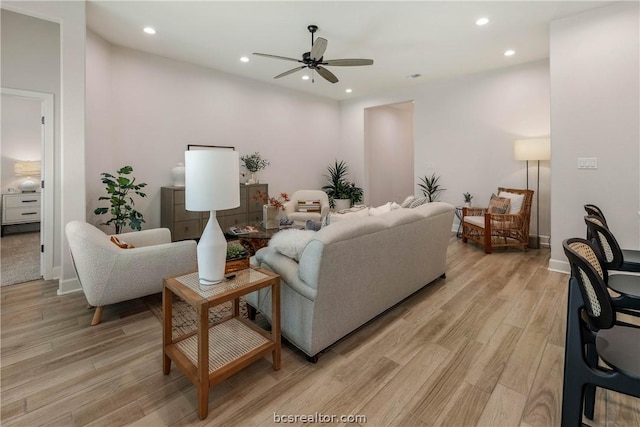 living room featuring ceiling fan and light hardwood / wood-style floors