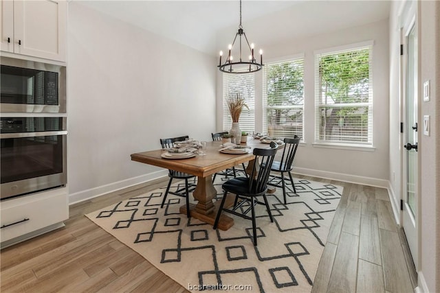 dining space with a notable chandelier and light wood-type flooring