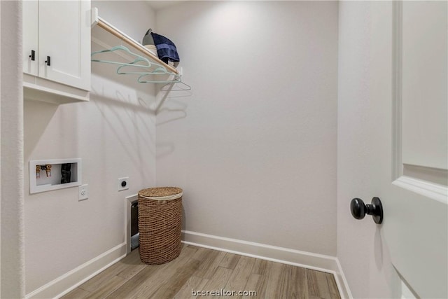 washroom with hookup for an electric dryer, washer hookup, cabinets, and light hardwood / wood-style flooring