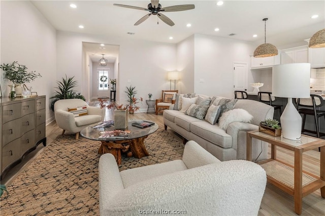 living room with ceiling fan and light hardwood / wood-style flooring