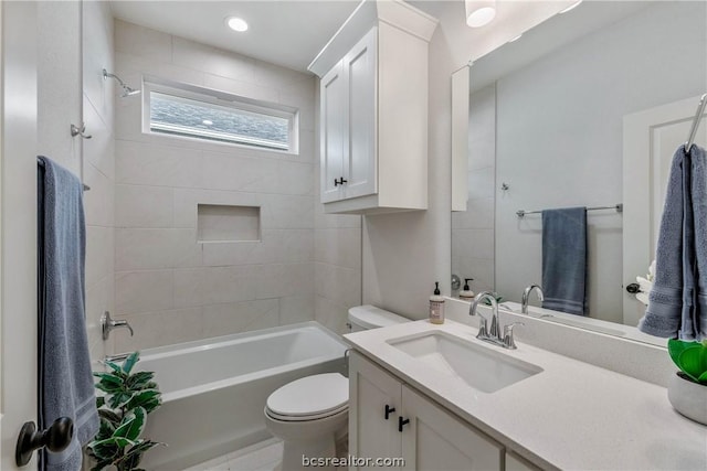 full bathroom with tiled shower / bath, vanity, and toilet