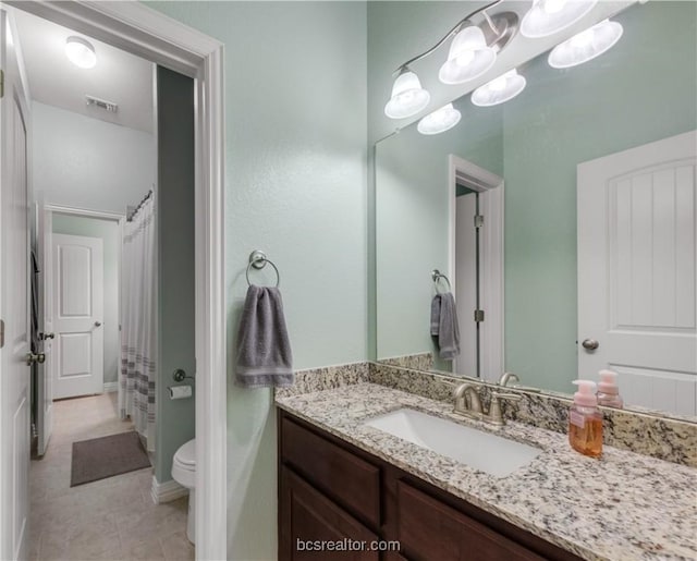 bathroom with a shower with shower curtain, vanity, toilet, and tile patterned floors