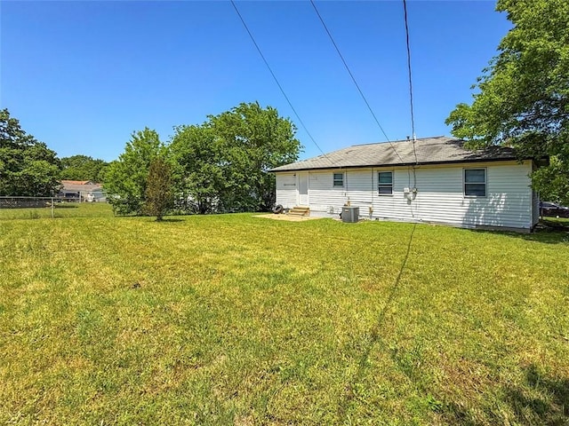 rear view of property with a lawn and central AC unit