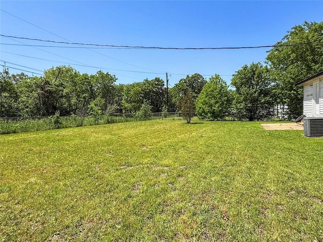 view of yard featuring fence and central air condition unit