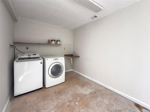 clothes washing area featuring visible vents, washing machine and clothes dryer, laundry area, and baseboards