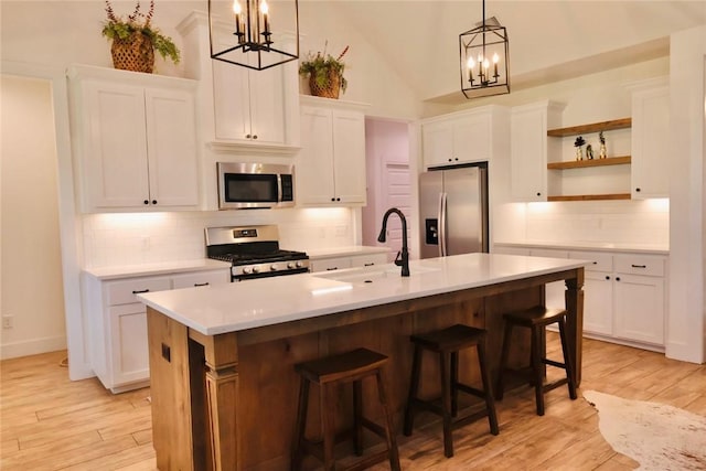 4020 Brownway Dr, College Station, TX 77845 - kitchen featuring stainless steel appliances, a chandelier, open shelves, white cabinets, and high vaulted ceiling