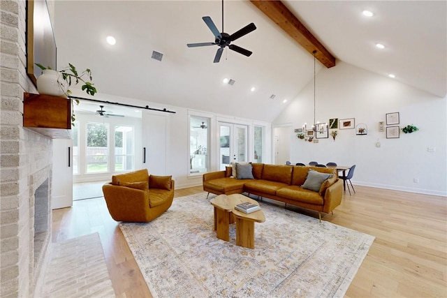 living room with ceiling fan with notable chandelier, high vaulted ceiling, beam ceiling, a fireplace, and visible vents