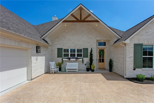 view of front of property featuring an attached garage, brick siding, roof with shingles, and a chimney
