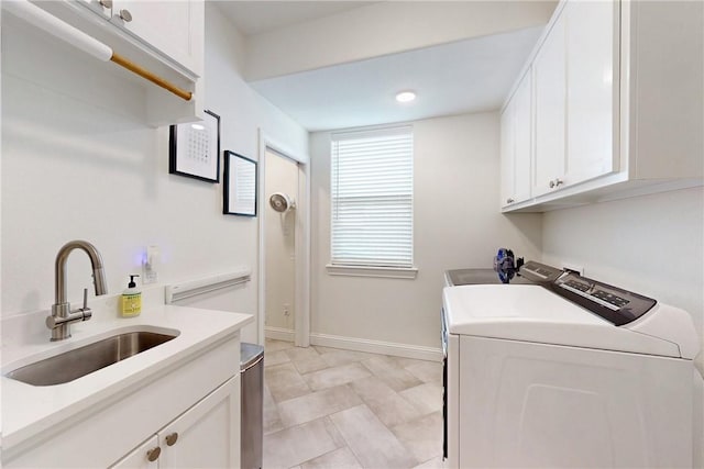 laundry area with a sink, washer and clothes dryer, cabinet space, and baseboards
