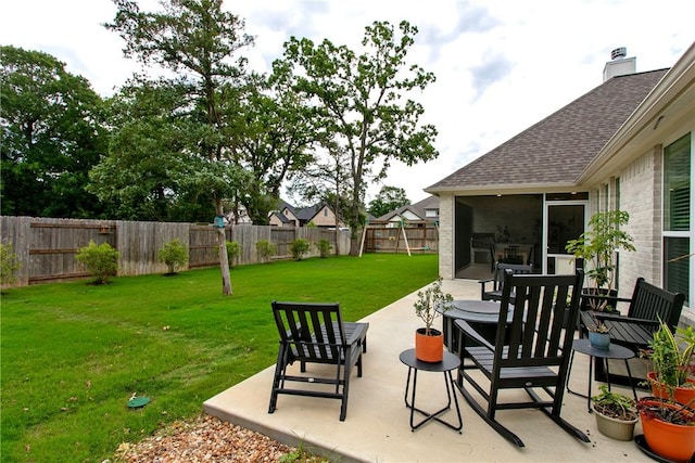 view of yard with a fenced backyard, a sunroom, and a patio