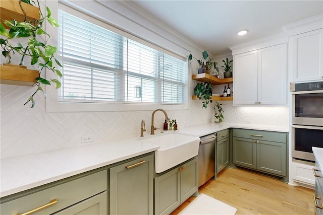 kitchen with green cabinets, stainless steel appliances, a sink, and plenty of natural light