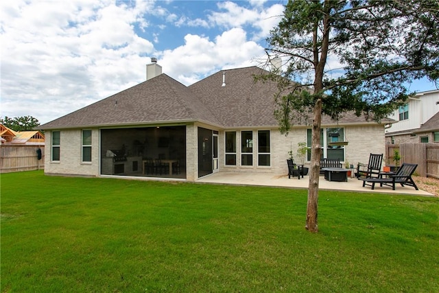 rear view of property with a patio, a chimney, a lawn, a shingled roof, and a fenced backyard