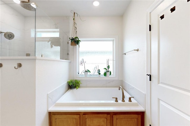 bathroom featuring a tile shower, a wealth of natural light, and a garden tub