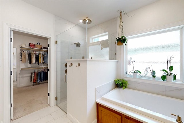 full bath with a stall shower, baseboards, a water view, a garden tub, and a walk in closet