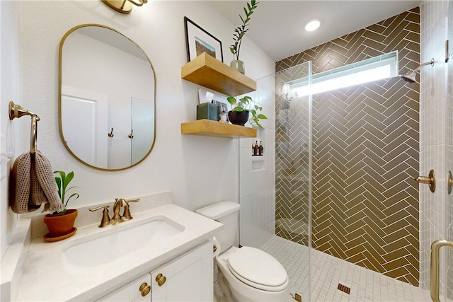 bathroom with vanity, toilet, tiled shower, and recessed lighting