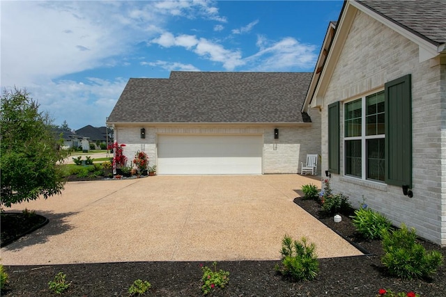 view of side of home featuring a shingled roof, concrete driveway, brick siding, and an attached garage