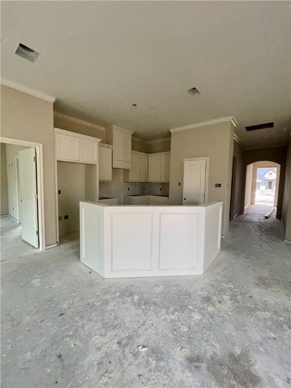 kitchen with white cabinetry, crown molding, and a center island