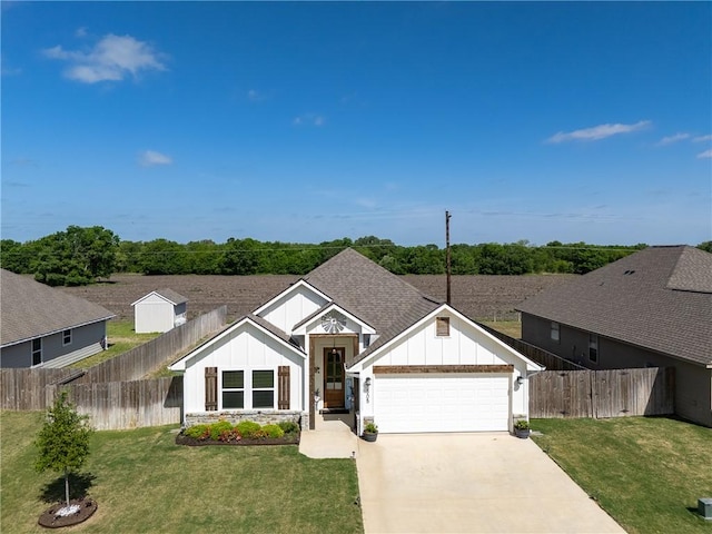 ranch-style house with board and batten siding, fence, a front lawn, a garage, and driveway