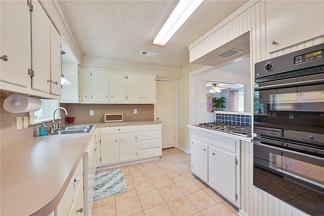 809 Coulter Dr S, Bryan, TX 77803 - kitchen featuring white cabinetry, sink, ceiling fan, double oven, and light tile patterned floors