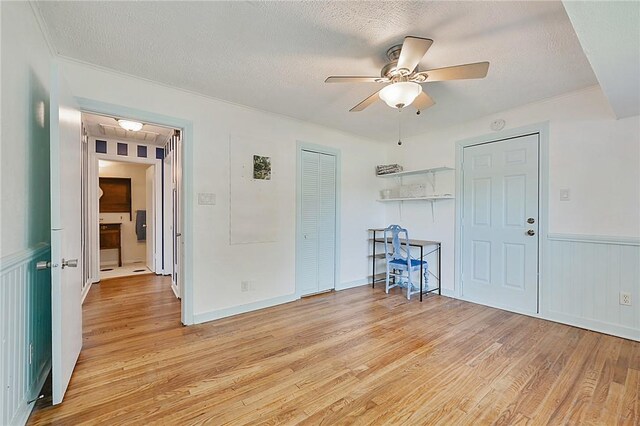 809 Coulter Dr S, Bryan, TX 77803 - spare room featuring ceiling fan, light wood-type flooring, and a textured ceiling