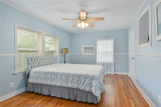 809 Coulter Dr S, Bryan, TX 77803 - bedroom with ceiling fan, crown molding, light hardwood / wood-style floors, and a textured ceiling