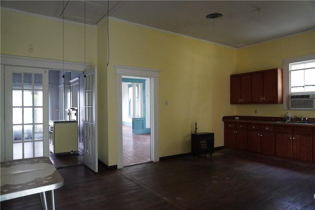608 W 27th St, Bryan, TX 77803 - kitchen featuring a sink, dark wood-style flooring, baseboards, and a wood stove