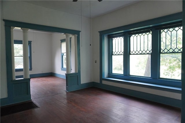 608 W 27th St, Bryan, TX 77803 - empty room featuring decorative columns, dark wood finished floors, and baseboards