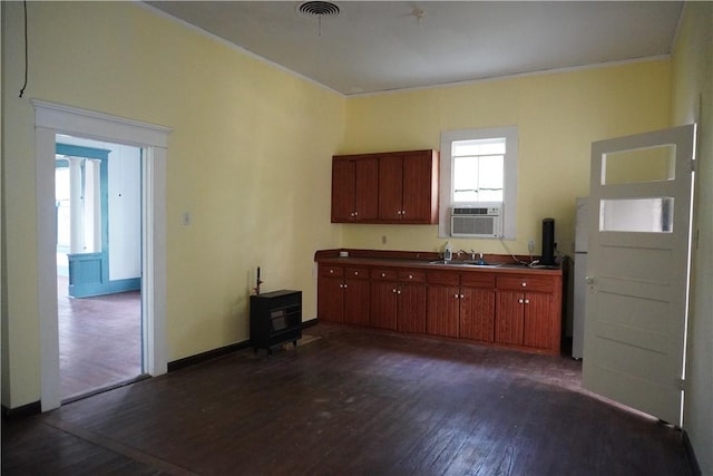 608 W 27th St, Bryan, TX 77803 - kitchen with dark wood finished floors, cooling unit, a sink, a wood stove, and baseboards