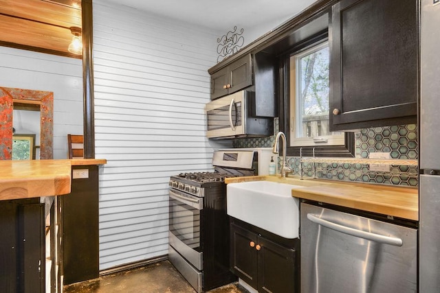 kitchen featuring tasteful backsplash, stainless steel appliances, and wooden counters