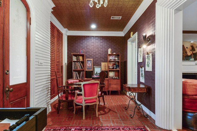 home office with a chandelier, crown molding, and brick wall