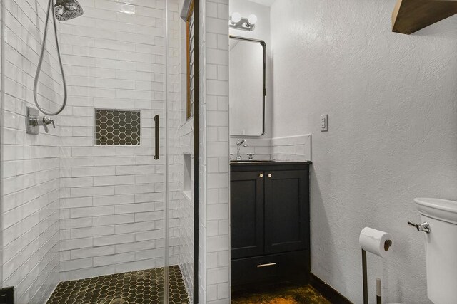 bathroom with walk in shower, vanity, and toilet