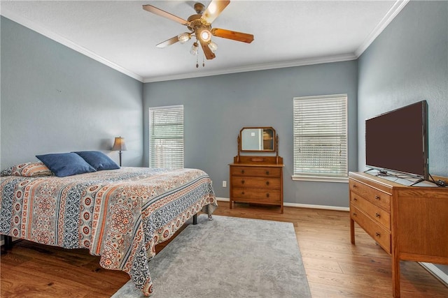 bedroom with ceiling fan, wood finished floors, baseboards, and ornamental molding