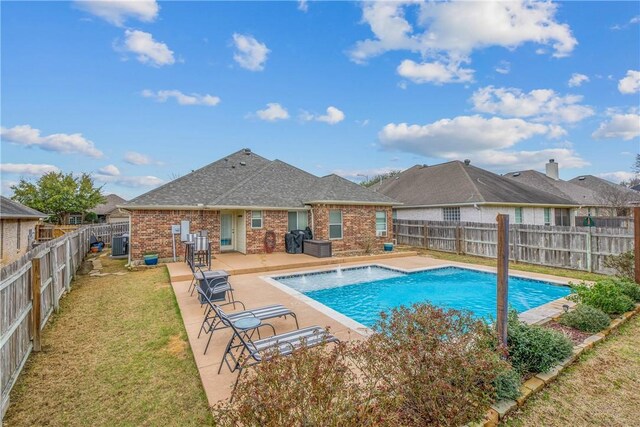 view of swimming pool with grilling area, a fenced in pool, a yard, a fenced backyard, and a patio area