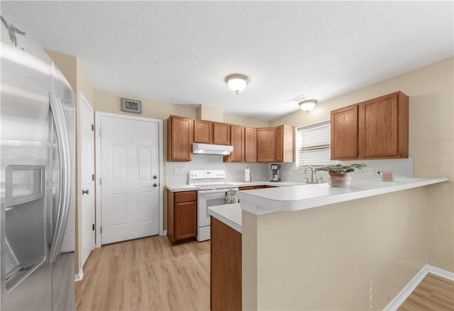 9939 County Road 272, Somerville, TX 77879 - kitchen with stainless steel fridge with ice dispenser, electric stove, under cabinet range hood, light wood finished floors, and a sink