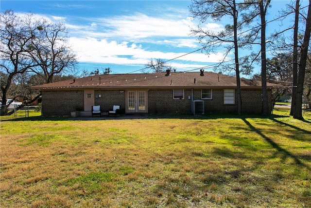 rear view of property with a yard, french doors, and cooling unit