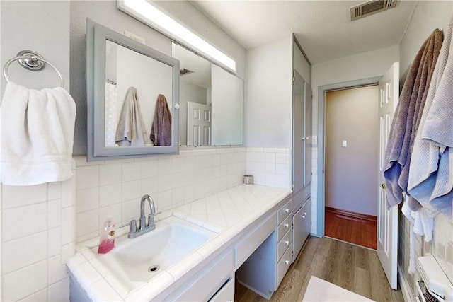 bathroom with tasteful backsplash, vanity, and wood-type flooring