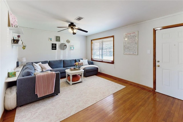 living room with hardwood / wood-style flooring, ceiling fan, and crown molding