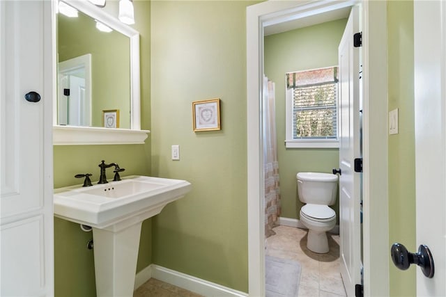 bathroom with tile patterned flooring, toilet, a sink, baseboards, and a shower with curtain