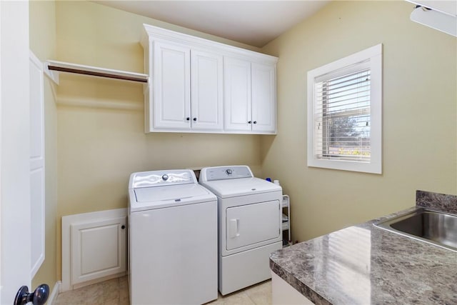 laundry area with independent washer and dryer, a sink, and cabinet space